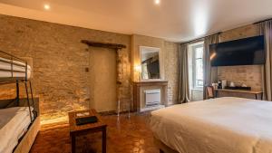 um quarto com uma cama grande e uma parede de pedra em Les Remparts Hôtels et Demeures Historiques em Beaune