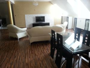 un soggiorno con due divani bianchi e una TV di Apartment Kotva a Bratislava