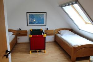 Habitación en el ático con 2 camas y una cama enrollada. en Ferienwohnung Sünnenkringel 54 en Zingst