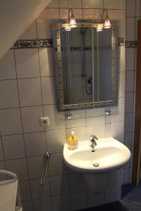 y baño con lavabo y espejo. en Ferienwohnung Sünnenkringel 54 en Zingst