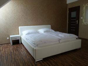 un letto con lenzuola e cuscini bianchi in una camera da letto di Apartment Kotva a Bratislava