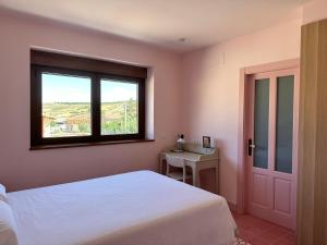 a bedroom with a white bed and a window at La Casa Rosa in Burgos +37 photos
