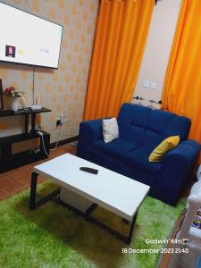 a living room with a blue couch and a table at Sifa Stays in Ongata Rongai 