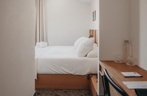 a bedroom with a bed and a desk with a mirror at Hotel Moderne in Porto-Vecchio