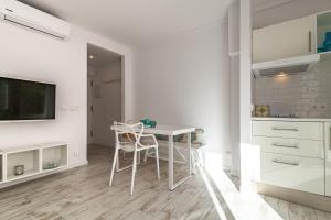 een witte keuken met een witte tafel en stoelen bij Apartment BEACH & RELAX in Port de Pollença