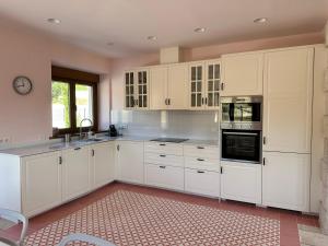 a large white kitchen with white cabinets and appliances at La Casa Rosa in Burgos