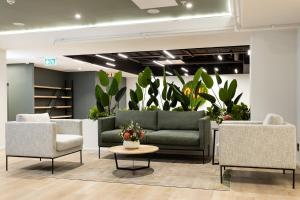a lobby with couches and chairs and plants at Habitat Aparthotel by Totalstay in Cape Town