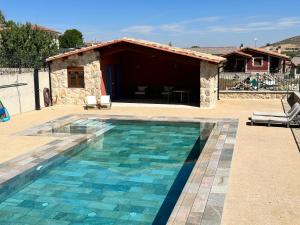 a swimming pool in front of a house at La Casa Rosa in Burgos