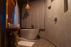 La salle de bains est pourvue d'une baignoire et d'un lavabo. dans l'établissement Vila Caetanos, à Amontada