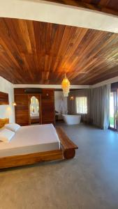 a bedroom with a bed with a wooden ceiling at Vila Caetanos in Amontada