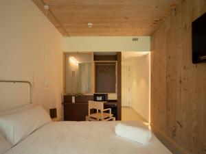 a bedroom with a bed and a desk with a chair at Hotel Amiuka in O Pedrouzo