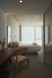 a room with a bed and a table and a bench at Hotel Amiuka in O Pedrouzo