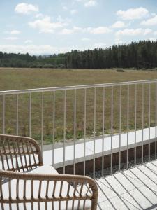 a wooden bench sitting on a balcony overlooking a field at Hotel Amiuka in O Pedrouzo