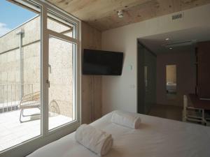 a bedroom with a bed and a large window at Hotel Amiuka in O Pedrouzo