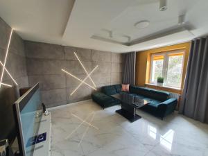 a living room with a green couch and a television at Apartament Dubaj in Gliwice