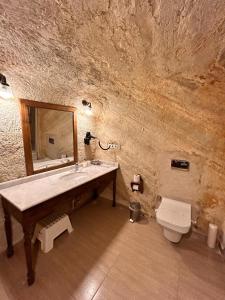 a stone bathroom with a sink and a toilet at Hotel Temenni Evi in Urgup