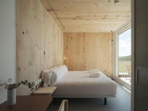 a bedroom with a white bed and a window at Hotel Amiuka in O Pedrouzo