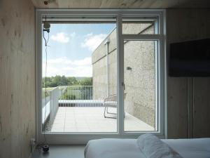 a bedroom with a view of a balcony at Hotel Amiuka in O Pedrouzo