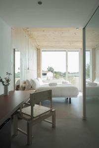 a bedroom with a bed and a table and a bench at Hotel Amiuka in O Pedrouzo