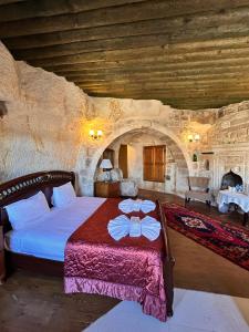 1 dormitorio con 1 cama en una habitación de piedra en Hotel Temenni Evi, en Ürgüp