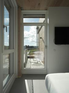 ein Schlafzimmer mit einem Fenster mit Blick auf einen Balkon in der Unterkunft Hotel Amiuka in O Pedrouzo