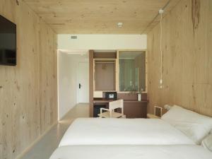a bedroom with a white bed and a desk at Hotel Amiuka in O Pedrouzo