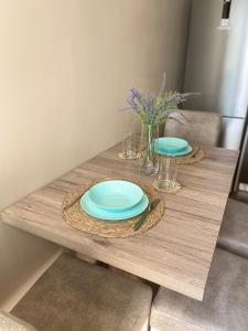 a wooden table with two plates and flowers on it at Catina`s Home in Burgas
