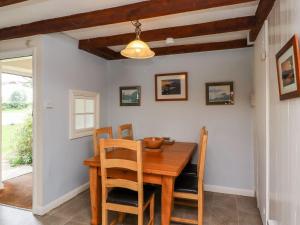 - une salle à manger avec une table et des chaises en bois dans l'établissement Cherry Tree Cottage, à Embleton