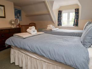 2 aparte bedden in een slaapkamer met handdoeken bij Cherry Tree Cottage in Embleton