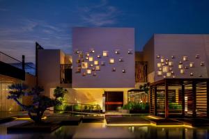 a building with a lot of windows on it at night at The Biltmore Hotel Villas in Dubai