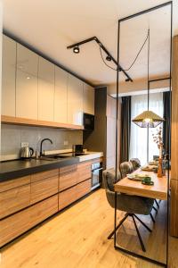 a kitchen with a table and a dining room at KOA - Fidelio Apartments in Braşov