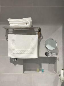 a bathroom with a shelf with towels and a mirror at شقق عالية الاطلالة Serv Apartment in Hafr Al-Batin +46 photos