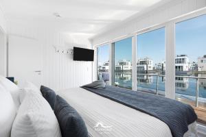a bedroom with a large bed and a large window at Harbour View Marina: Dachterrasse, Meerblick, Sauna, Bootsanleger in Olpenitz