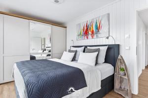 a bedroom with a large bed in a white room at 5 Beaufort - Wasserhaus, Meerblick, Sauna, Dachterrasse, Bootsanleger, Strandkorb in Olpenitz