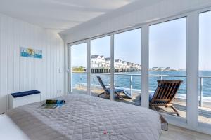 1 dormitorio con cama y vistas al océano en Wasserhaus Klabautermann en Olpenitz