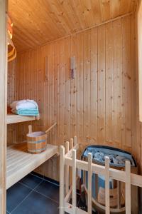 a sauna with a hot tub and wooden walls at Wasserhaus Klabautermann in Olpenitz