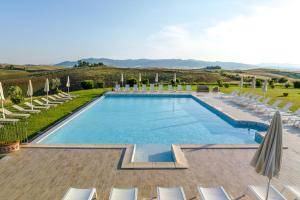 einen Pool mit Stühlen und Sonnenschirmen in einem Resort in der Unterkunft Agriturismo Panieracci in Villamagna
