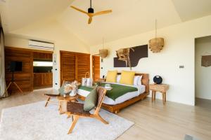 een slaapkamer met een bed en een woonkamer bij Wild Cottages Elephant Sanctuary Resort in Nathon Bay