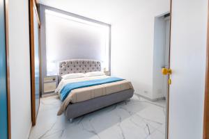 een witte slaapkamer met een bed en een spiegel bij Casa Cate in Rome