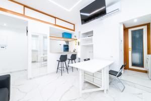 een witte keuken met een witte tafel en stoelen bij Casa Cate in Rome