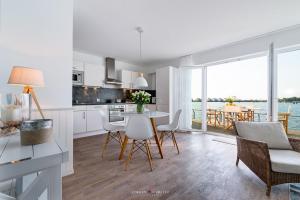 una cucina e un soggiorno con tavolo e sedie di Ferienwohnung Pier 51 a Olpenitz