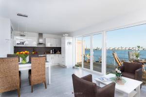 a kitchen and dining room with a view of the ocean at Ferienwohnung Hafenblick in Olpenitz