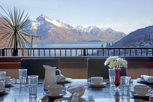 a dining table with a view of a mountain at Queenstown House Boutique Hotel & Apartments in Queenstown