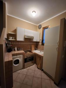 ミラノにあるSempione Apartmentのキッチン(白い冷蔵庫、食器洗い機付)