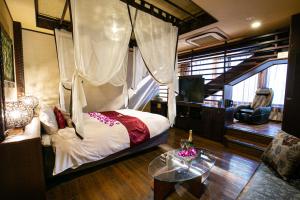 a bedroom with a canopy bed and a living room at Hotel Balian Resort Shinjuku Honten (Adult Only) in Tokyo