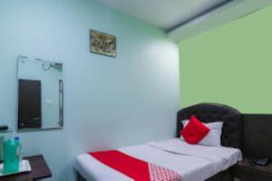 1 dormitorio con cama, escritorio y espejo en Club House Guest House,Bhubaneswar, en Bhubaneshwar