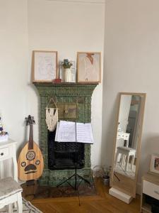 een kamer met een open haard met een gitaar en een spiegel bij Appartement vue sur Tour Eiffel à 5 min de Paris in Issy-les-Moulineaux