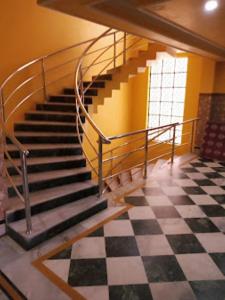 una escalera en una habitación con suelo a cuadros en Hotel Gokul Plaza,Bhubaneswar, en Bhubaneshwar