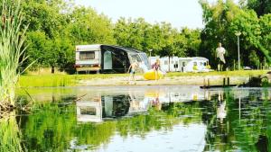 eine Gruppe von Menschen auf einem Campingplatz in der Nähe eines Sees in der Unterkunft Vakantiepark de Toffe Peer in Ruinerwold