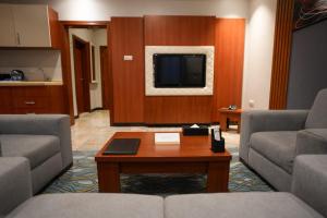 un soggiorno con 2 divani e una TV di فندق قصر توبال للشقق المخدومة a Gedda